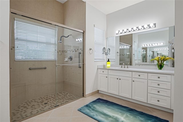 bathroom featuring tile patterned floors, a shower with shower door, and vanity