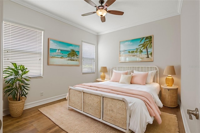 bedroom featuring ornamental molding, multiple windows, wood-type flooring, and ceiling fan