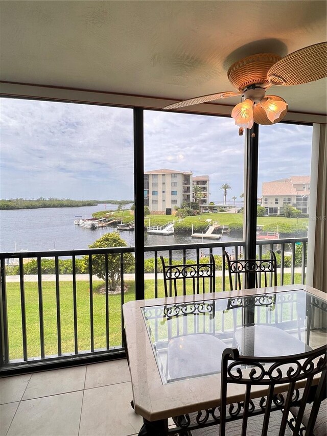 sunroom / solarium featuring a water view, ceiling fan, and a wealth of natural light