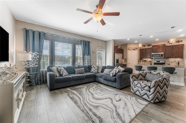 living area featuring ceiling fan, light wood finished floors, and recessed lighting