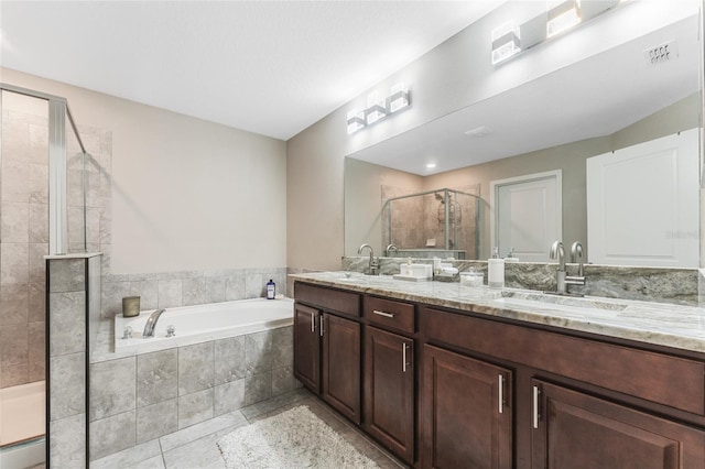 bathroom featuring double vanity, a stall shower, a sink, and visible vents