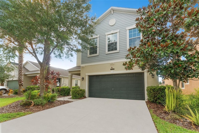 view of front of house featuring a garage, driveway, and stucco siding