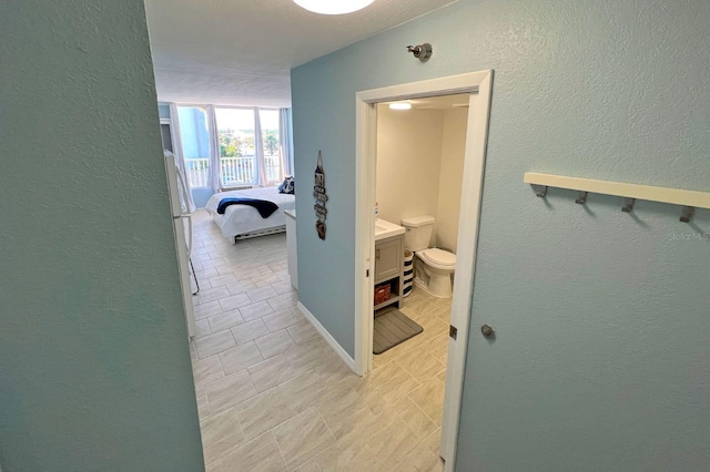 corridor featuring a textured ceiling and light tile patterned floors