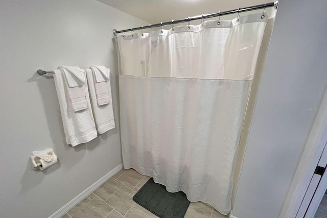 bathroom featuring walk in shower and tile patterned flooring