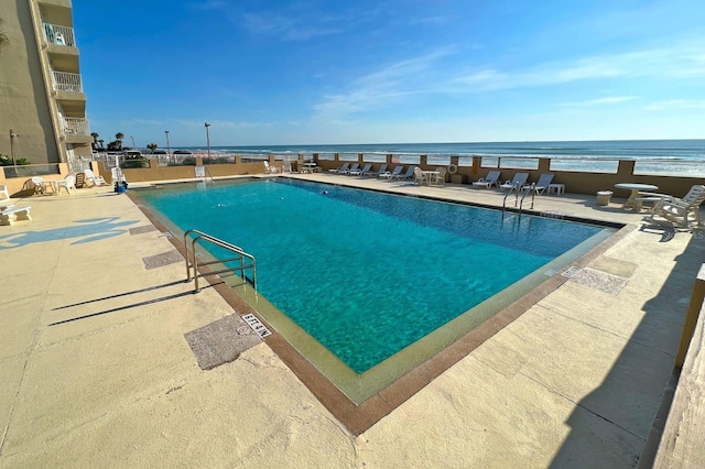 view of pool featuring a patio area and a water view