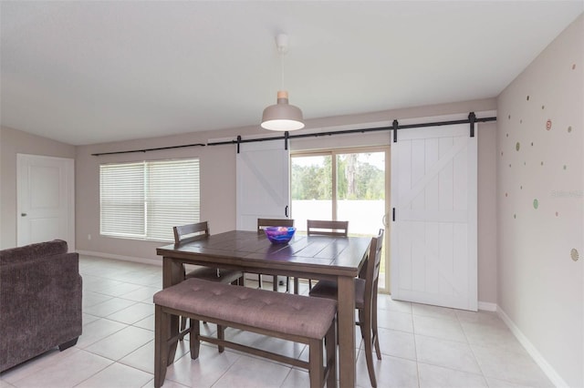 tiled dining room featuring a barn door