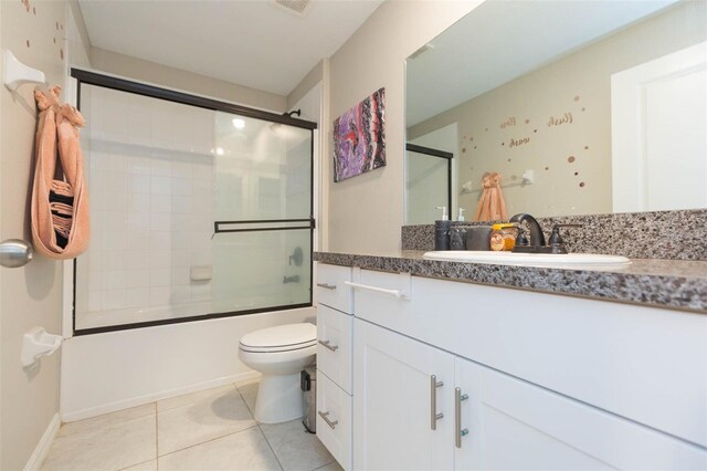 full bathroom with shower / bath combination with glass door, vanity, toilet, and tile patterned flooring