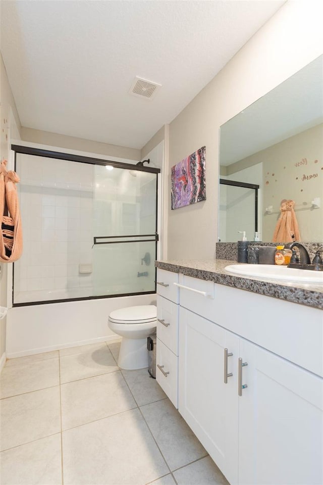 full bathroom with shower / bath combination with glass door, vanity, toilet, and tile patterned flooring