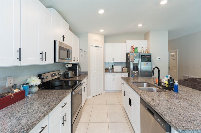 kitchen with sink, appliances with stainless steel finishes, white cabinetry, and decorative backsplash