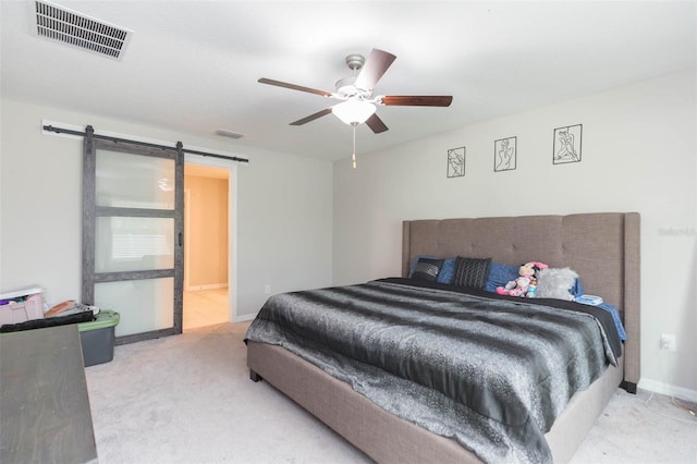 bedroom featuring a barn door, ceiling fan, and carpet floors