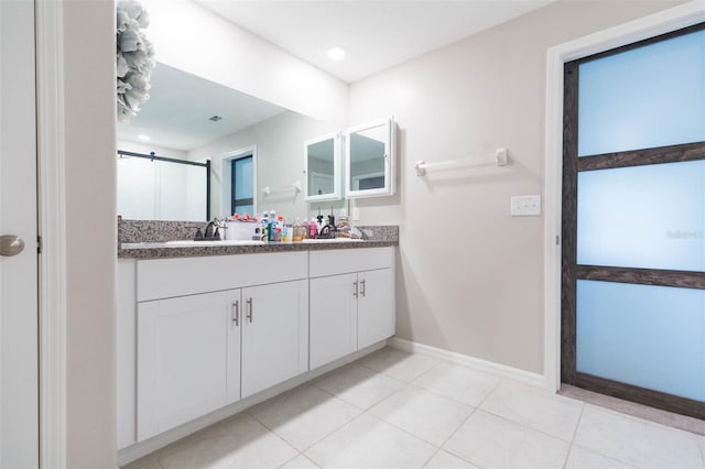 bathroom featuring tile patterned floors, a shower with shower door, and vanity