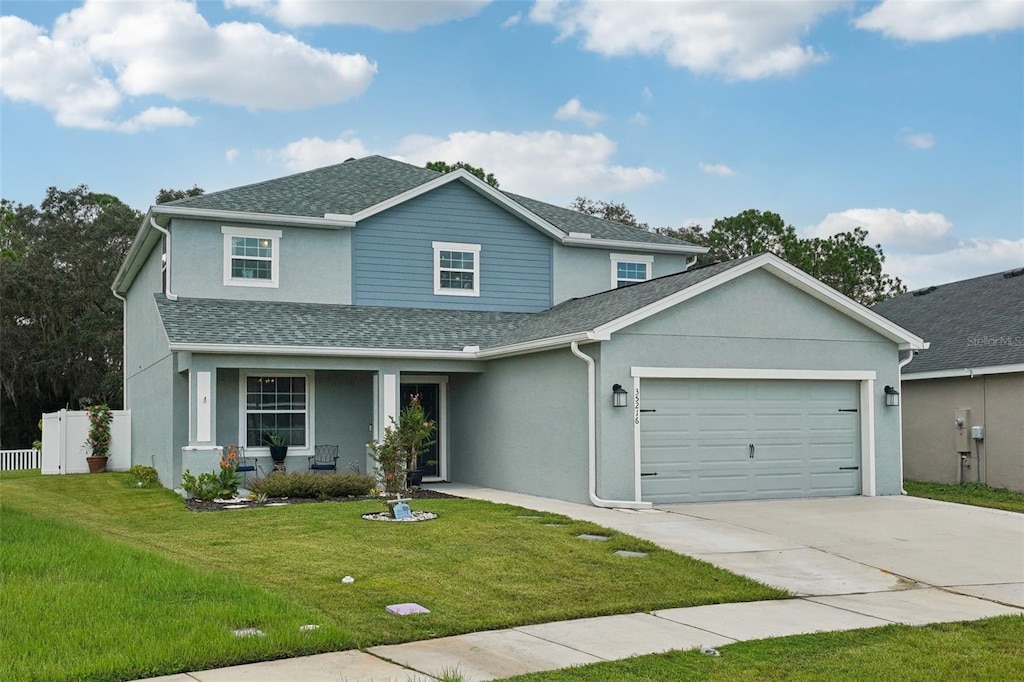 view of front of home with a garage, a porch, and a front lawn