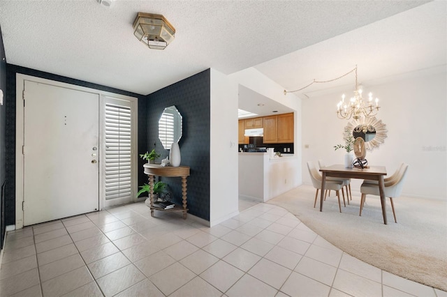 foyer featuring a textured ceiling, an inviting chandelier, and light colored carpet