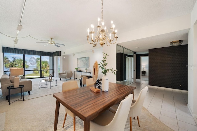 dining room featuring ceiling fan with notable chandelier, light tile patterned floors, and a textured ceiling