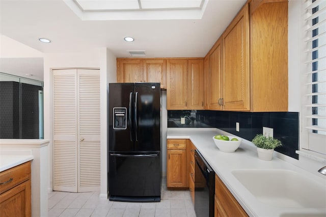 kitchen featuring black appliances, sink, light tile patterned floors, and backsplash