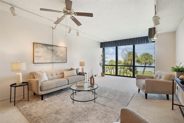 carpeted living room with a textured ceiling, rail lighting, and ceiling fan