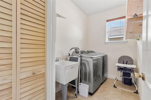 laundry area featuring light tile patterned floors and washing machine and dryer