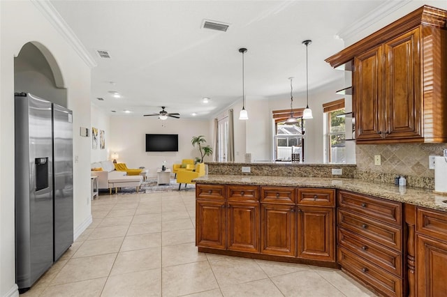 kitchen with hanging light fixtures, stainless steel fridge, light tile patterned floors, ceiling fan, and ornamental molding