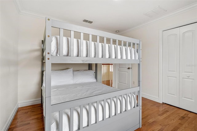 bedroom featuring ornamental molding, a closet, and hardwood / wood-style floors