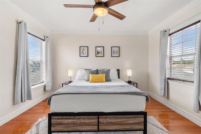 bedroom featuring light hardwood / wood-style flooring, ceiling fan, and ornamental molding