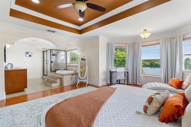 bedroom with multiple windows, crown molding, light wood-type flooring, and ceiling fan