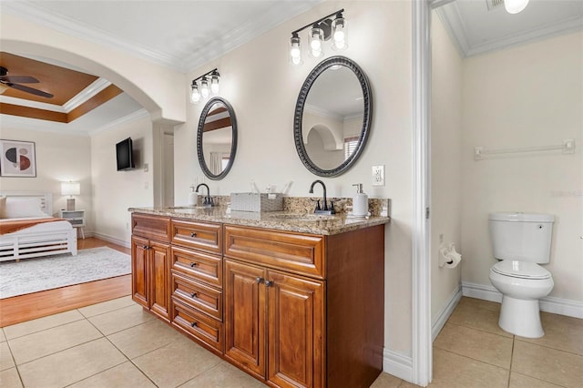 bathroom with ceiling fan, vanity, ornamental molding, hardwood / wood-style flooring, and toilet