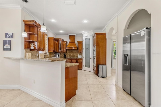 kitchen featuring premium range hood, hanging light fixtures, stainless steel fridge, and kitchen peninsula