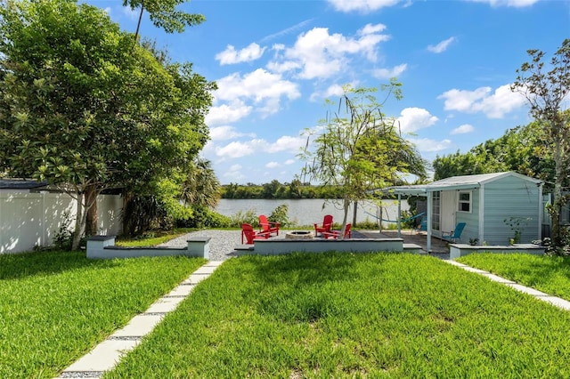 view of yard featuring a storage shed and a water view