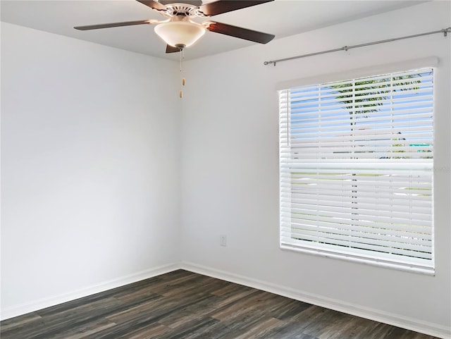 spare room featuring ceiling fan, baseboards, and dark wood-style flooring