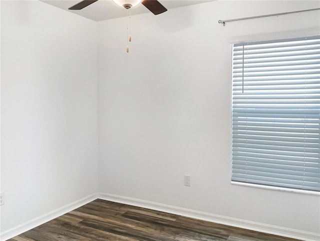 unfurnished room featuring dark wood finished floors, a ceiling fan, and baseboards