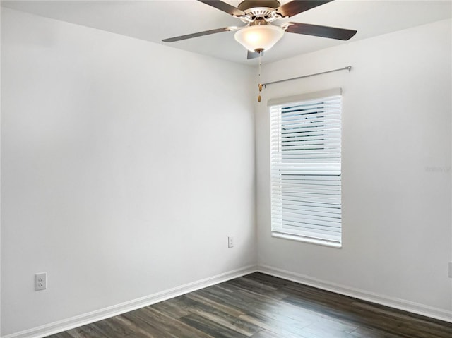 spare room with a ceiling fan, dark wood-style floors, and baseboards