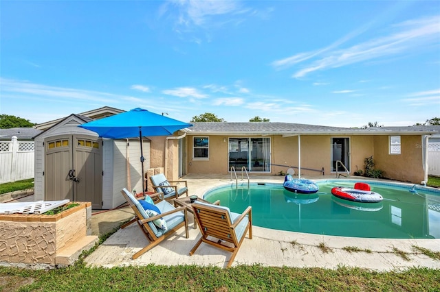 view of swimming pool featuring a patio area and a shed