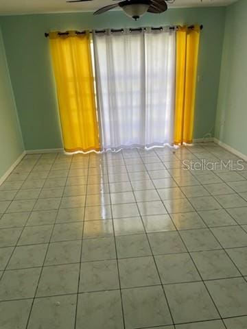 spare room featuring ceiling fan and light tile patterned flooring