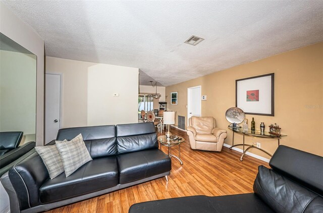 living room with a textured ceiling and light hardwood / wood-style floors