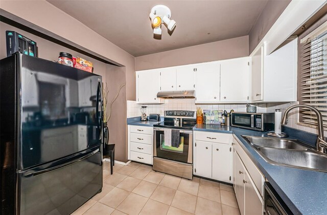 kitchen featuring appliances with stainless steel finishes, light tile patterned floors, white cabinetry, and sink