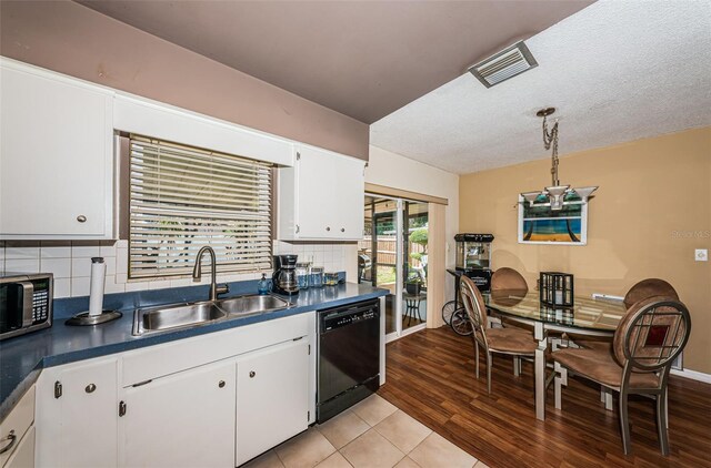 kitchen featuring white cabinets, dishwasher, light wood-type flooring, sink, and decorative backsplash