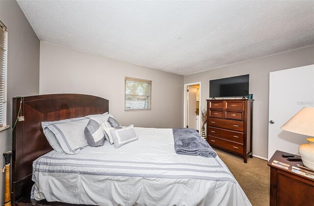 bedroom featuring a textured ceiling and carpet flooring