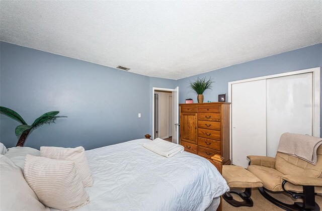 bedroom featuring a textured ceiling, a closet, and carpet floors