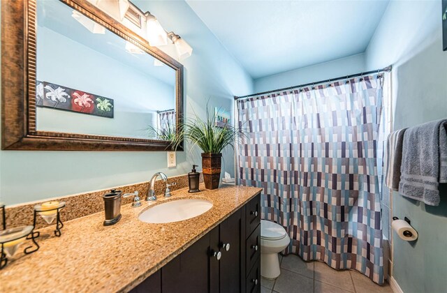 bathroom featuring vanity, toilet, walk in shower, and tile patterned floors