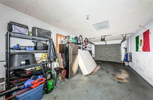 garage with a garage door opener and stainless steel fridge