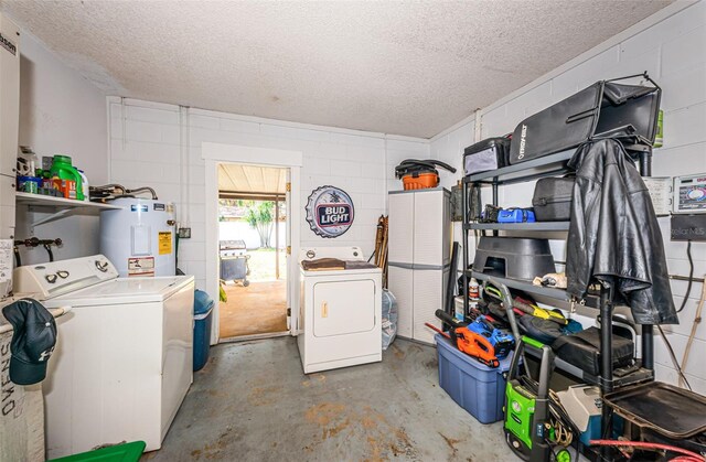 laundry area with washer and dryer, a textured ceiling, and water heater