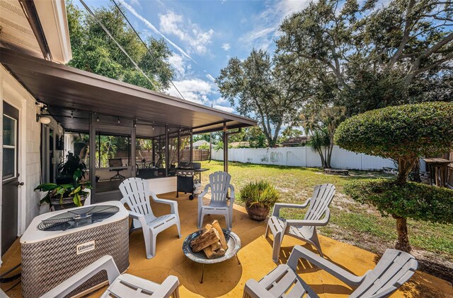 view of patio featuring an outdoor fire pit, a sunroom, and cooling unit