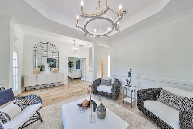 living room with a chandelier, hardwood / wood-style flooring, and a raised ceiling