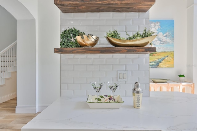 room details with baseboards, decorative backsplash, and wood finished floors