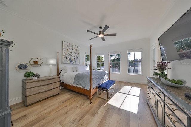 bedroom featuring light wood-style flooring, baseboards, and ceiling fan