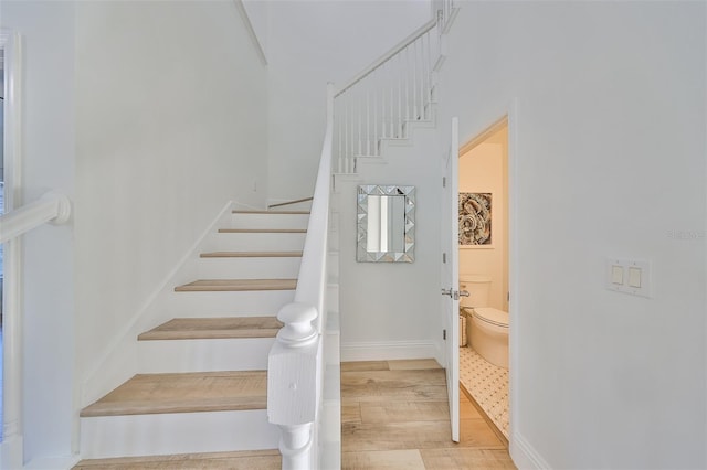 stairs with baseboards and wood finished floors