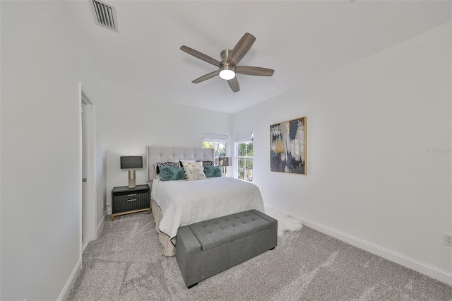 carpeted bedroom featuring a ceiling fan, visible vents, and baseboards