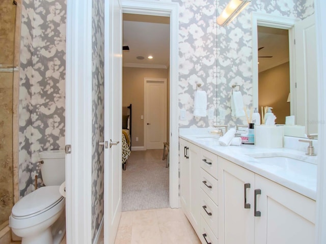 bathroom featuring toilet, ornamental molding, and vanity