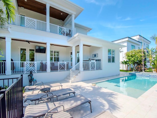 back of house featuring ceiling fan, a balcony, and a patio