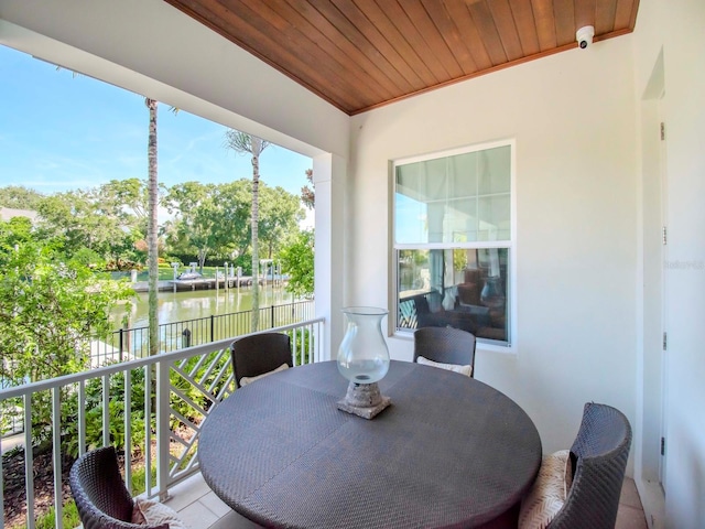 sunroom featuring a water view and wood ceiling